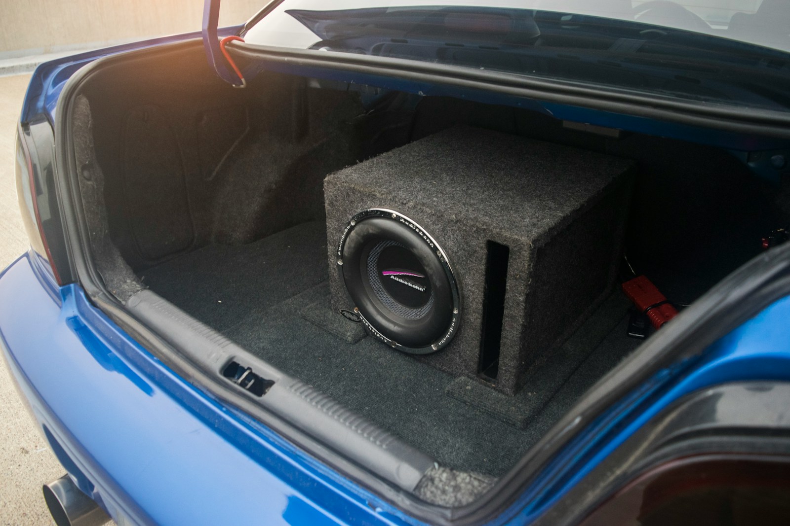 A car trunk contains a subwoofer system.