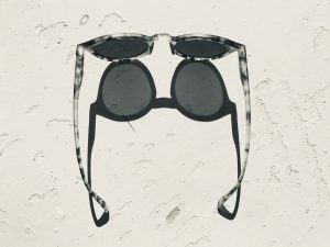 black sunglasses on white sand
