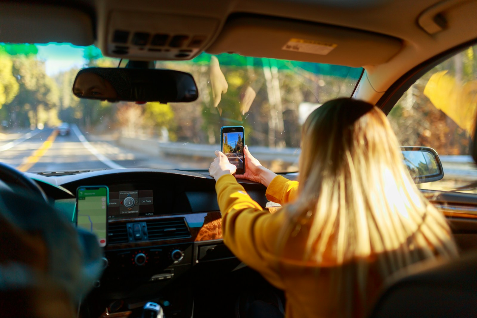road trip a woman driving a car with a cell phone in her hand