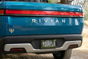the back end of a blue car with a license plate